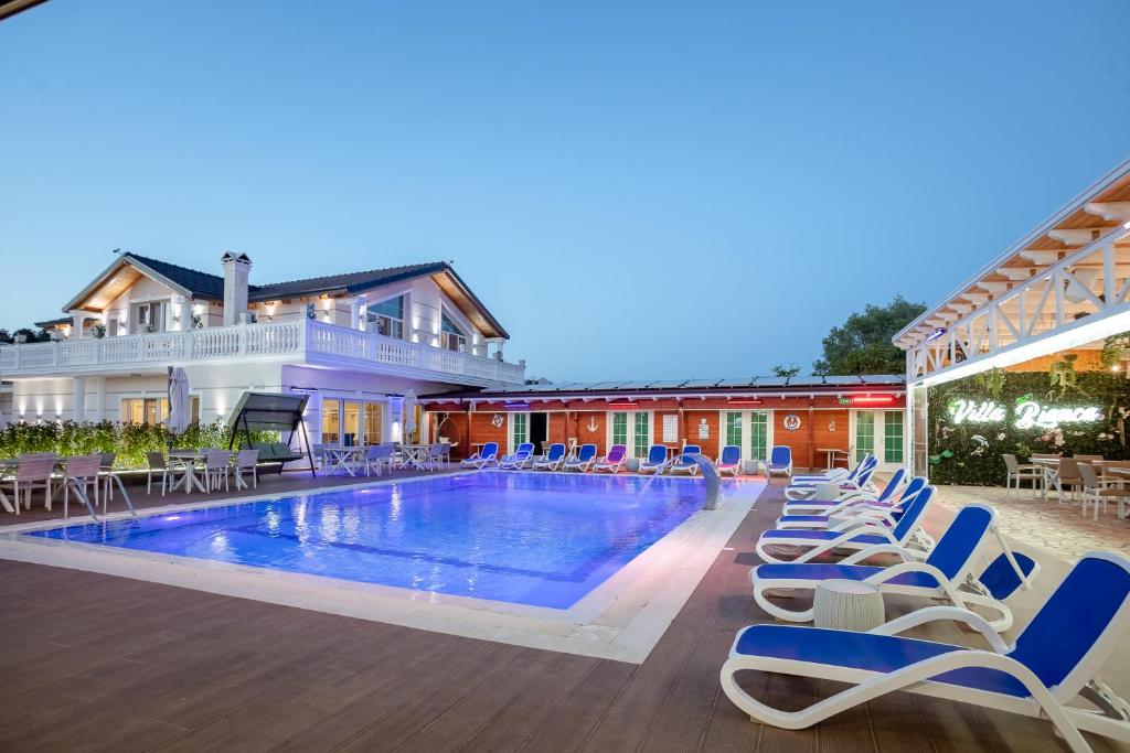 una piscina resort con tumbonas y un hotel en Villa Bianca, en Rubjekë