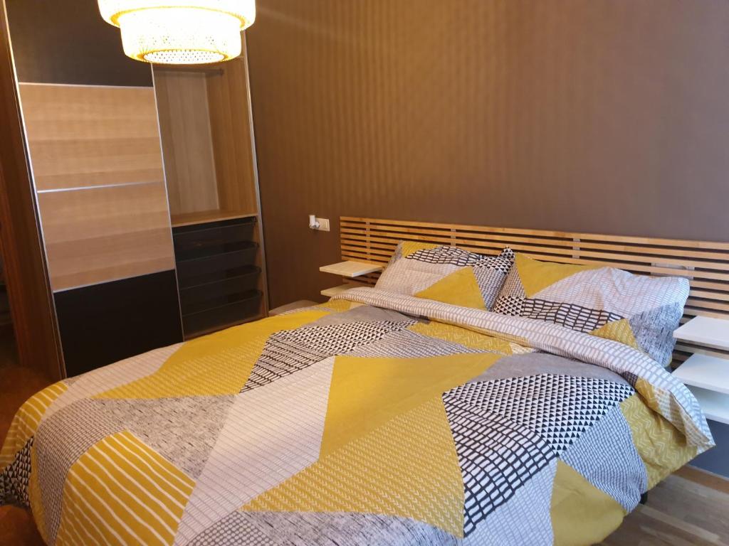 sypialnia z łóżkiem z kolorową kołdrą w obiekcie Alberto Astur Habitaciones privadas màs cocina compartida w mieście Oviedo