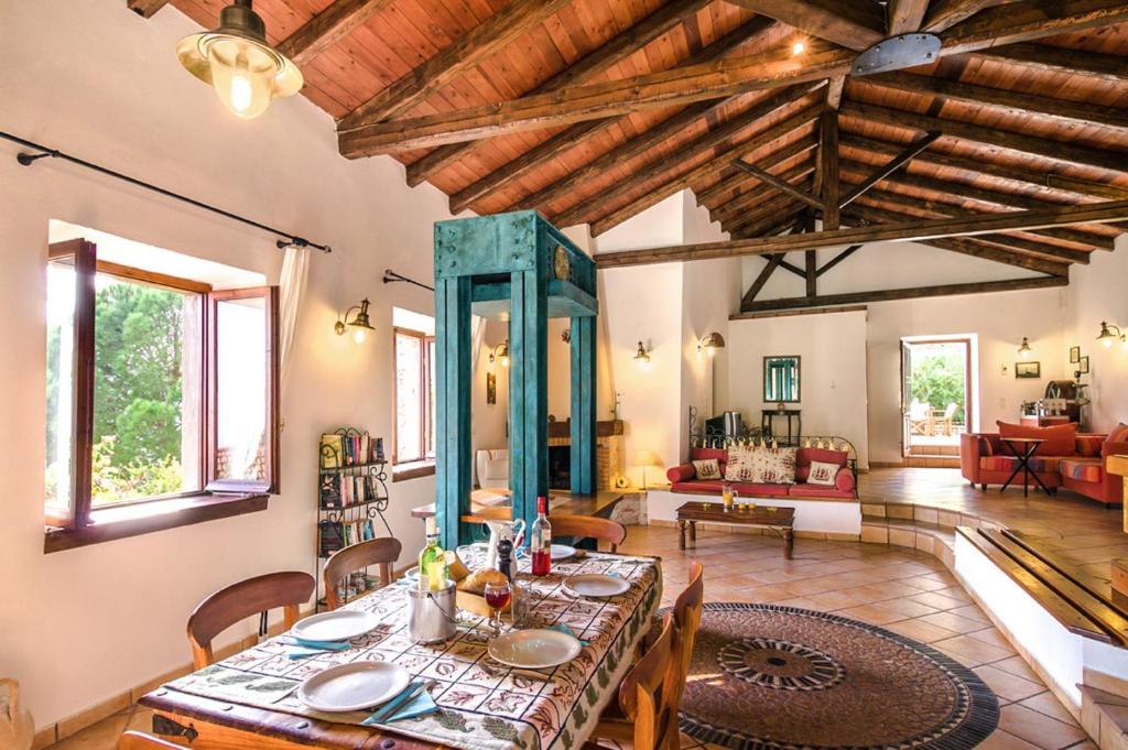 Un comedor con mesa y sillas y una sala de estar. en Villa Lithari, Nissaki, Corfu, en Vlikatsoúri