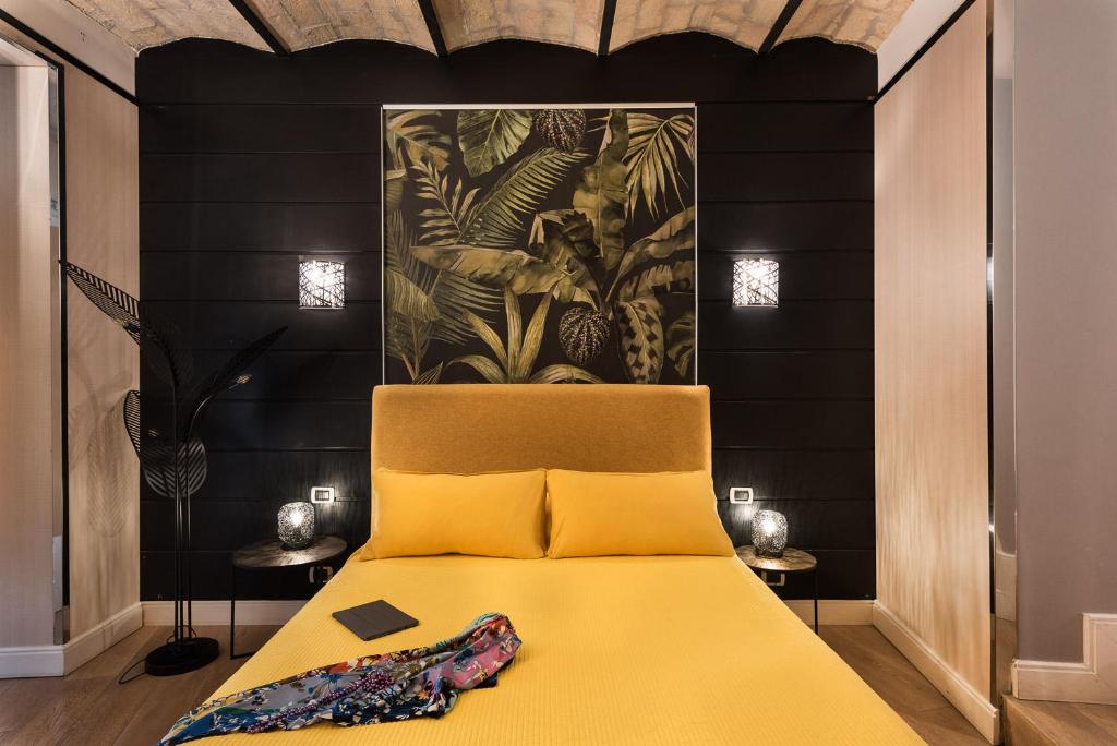 a bedroom with a yellow bed with a painting on the wall at Idyllia - Colosseum luxury apartment in Rome