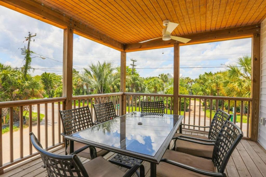 a screened in porch with a glass table and chairs at Carolina Breezes West in Isle of Palms
