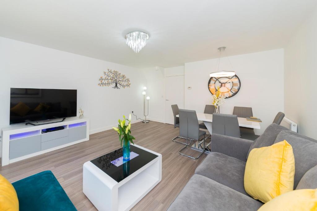 a living room with a couch and a dining room at Greenfield Modern 3BR Home - Southcote lane , Reading in Reading