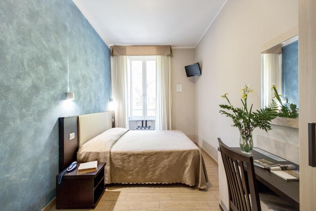 1 dormitorio con 1 cama y escritorio en una habitación en Buonarroti Suite, en Roma