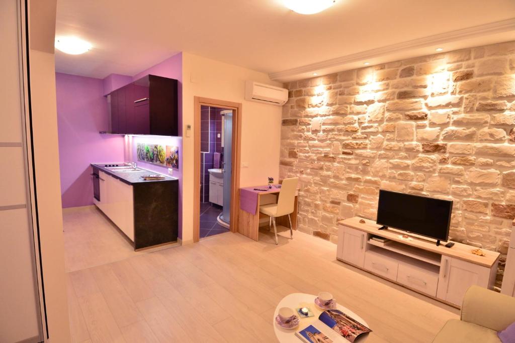 een keuken en een woonkamer met een stenen muur bij Apartment Scents of Dubrovnik in Dubrovnik