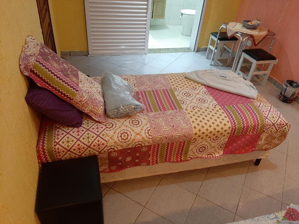 a bed with a blanket and pillows on it at Pousada Exuberance in Diadema