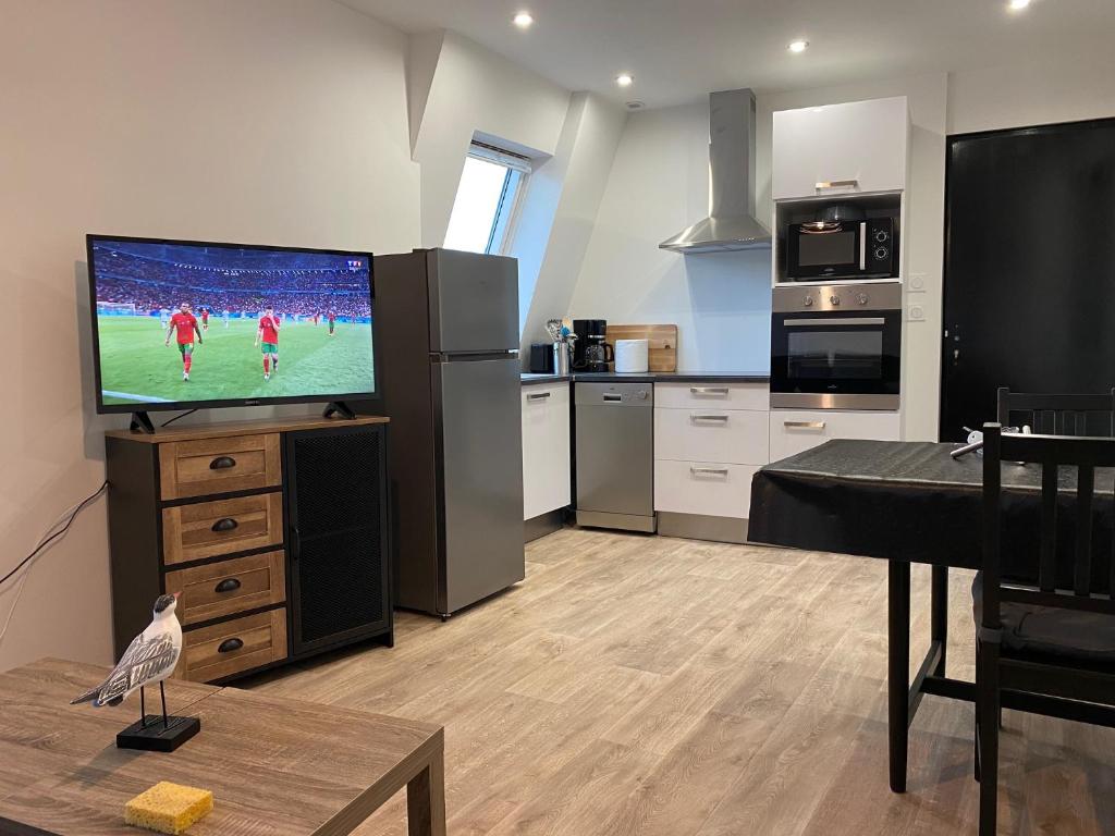 Il comprend un salon avec une télévision et une cuisine. dans l'établissement Centre ville Granville à 50m de la mer - ANCV accepté, à Granville