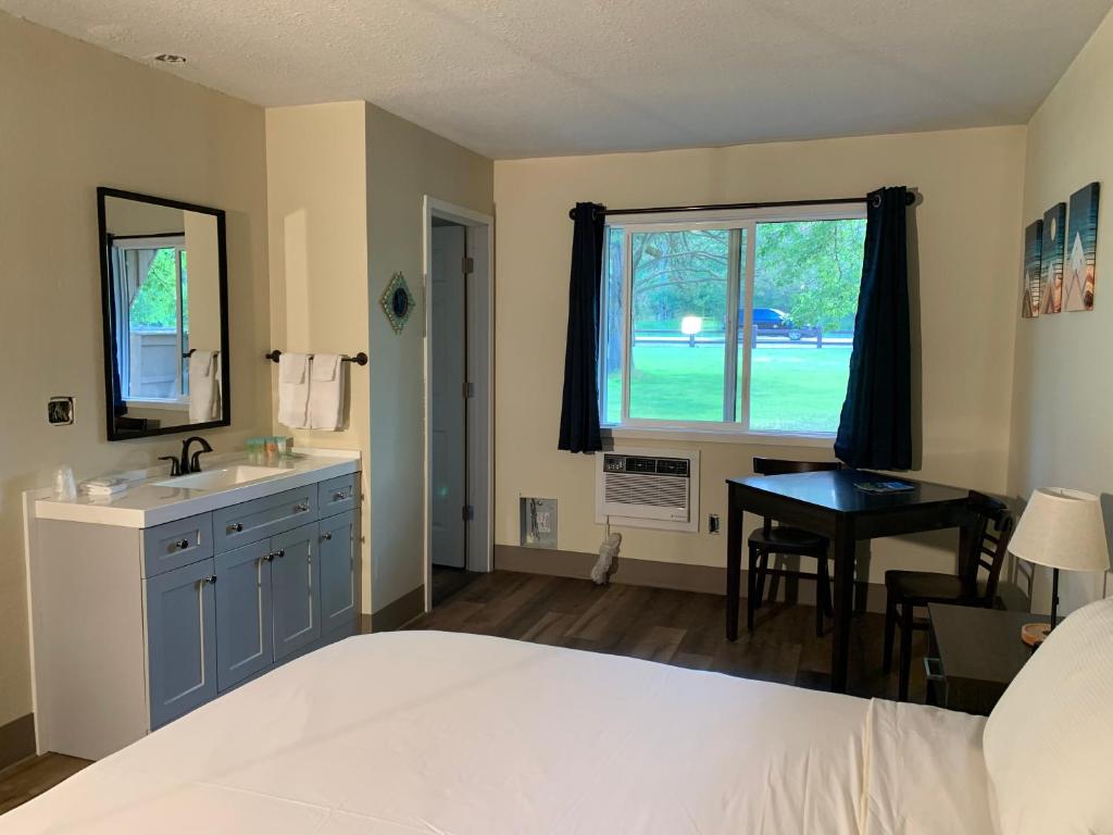 a bedroom with a bed and a sink and a window at Winthrop Inn in Winthrop