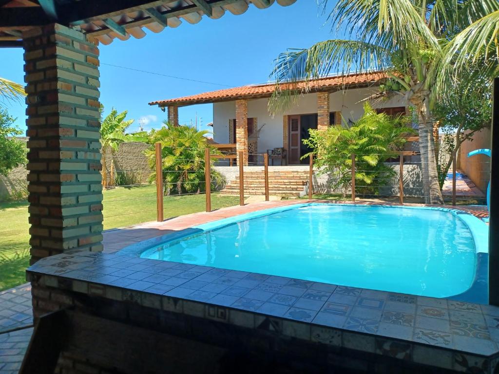 a swimming pool in front of a house at Morro Branco, Beberibe-CE in #N/A