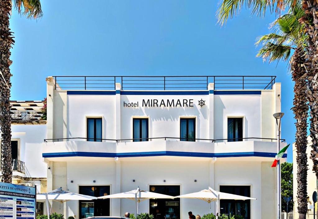 un edificio bianco con un cartello che legge l'hotel miramare di Hotel Miramare a Otranto