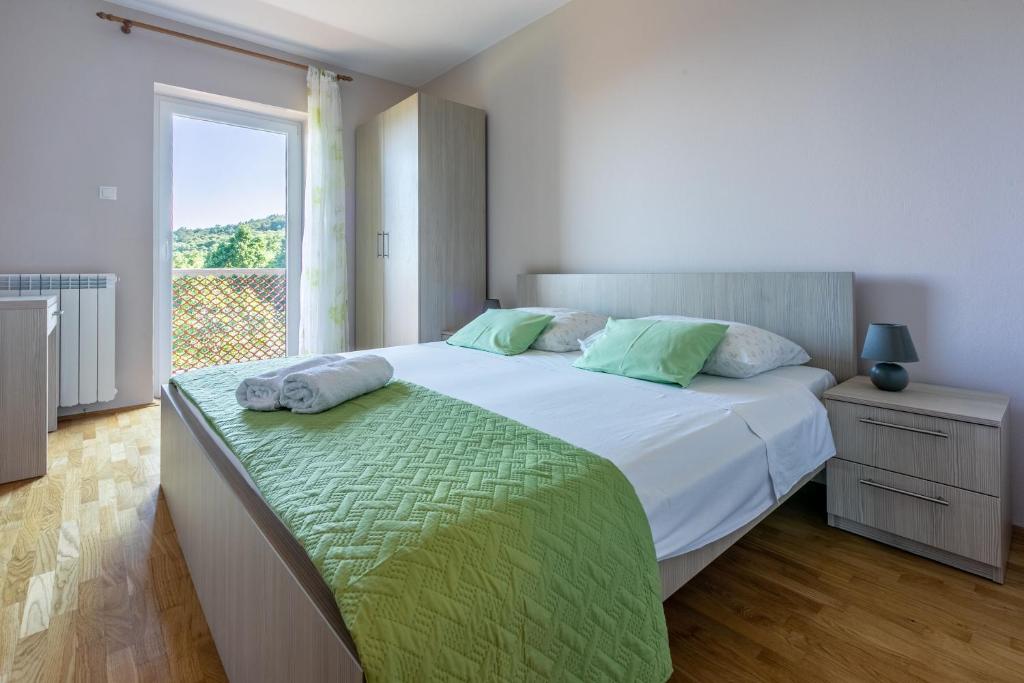 sypialnia z dużym łóżkiem i oknem w obiekcie House Vicky w mieście Mošćenice