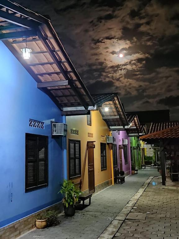 a row of colorful buildings at night at Pousada Pier 123 in Penha