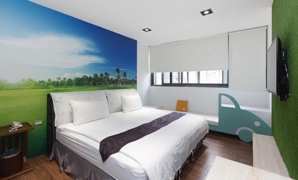 礁溪鄉的住宿－π 園周綠溫泉會館 Pi Hotspring Resort，卧室配有一张大床,墙上挂有绘画作品