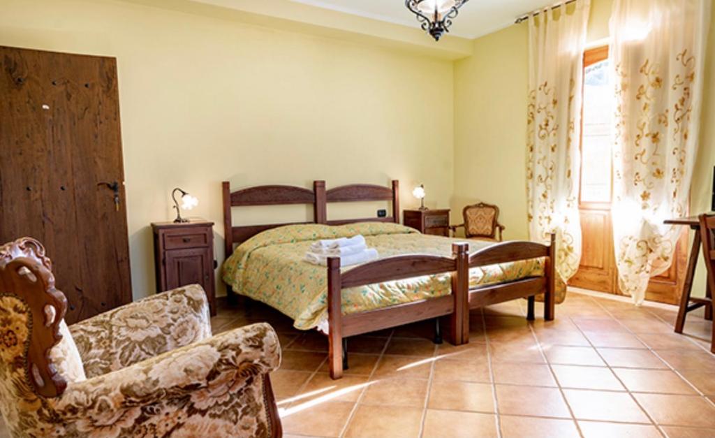 a bedroom with a bed and a couch and a chair at Tenuta Montelaura in Forino