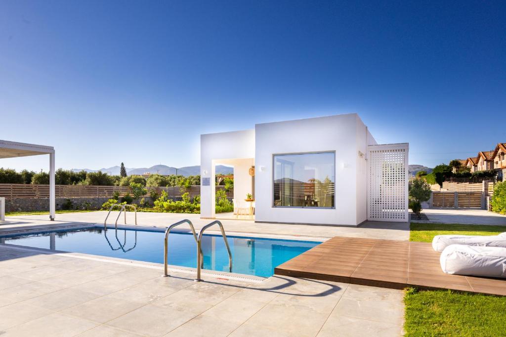 a villa with a swimming pool and a house at Sardines Luxury Villas in Analipsi