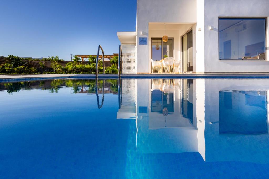 a house with a swimming pool with blue water at Sardines Luxury Villas in Analipsi