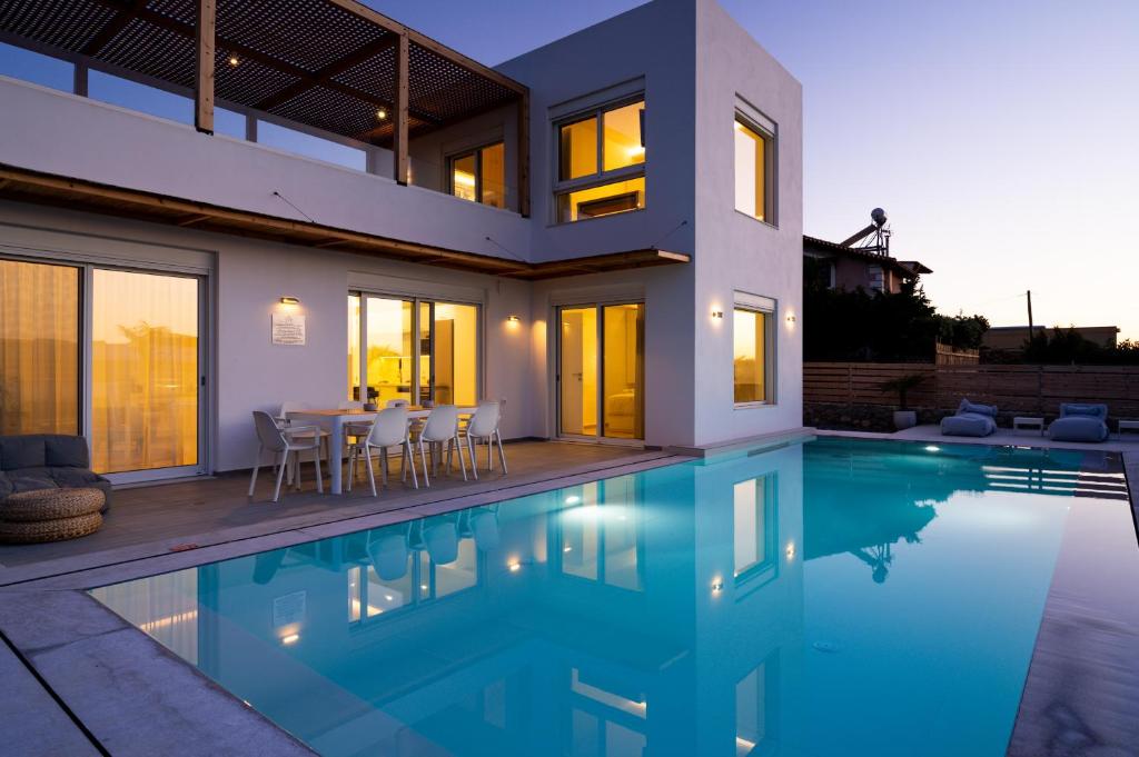 a house with a swimming pool in front of it at Sardines Luxury Villas in Analipsi