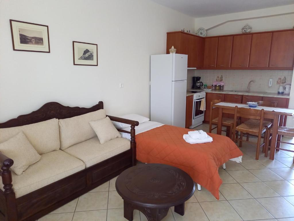 a living room with a couch and a kitchen at To Pithari in Skiros