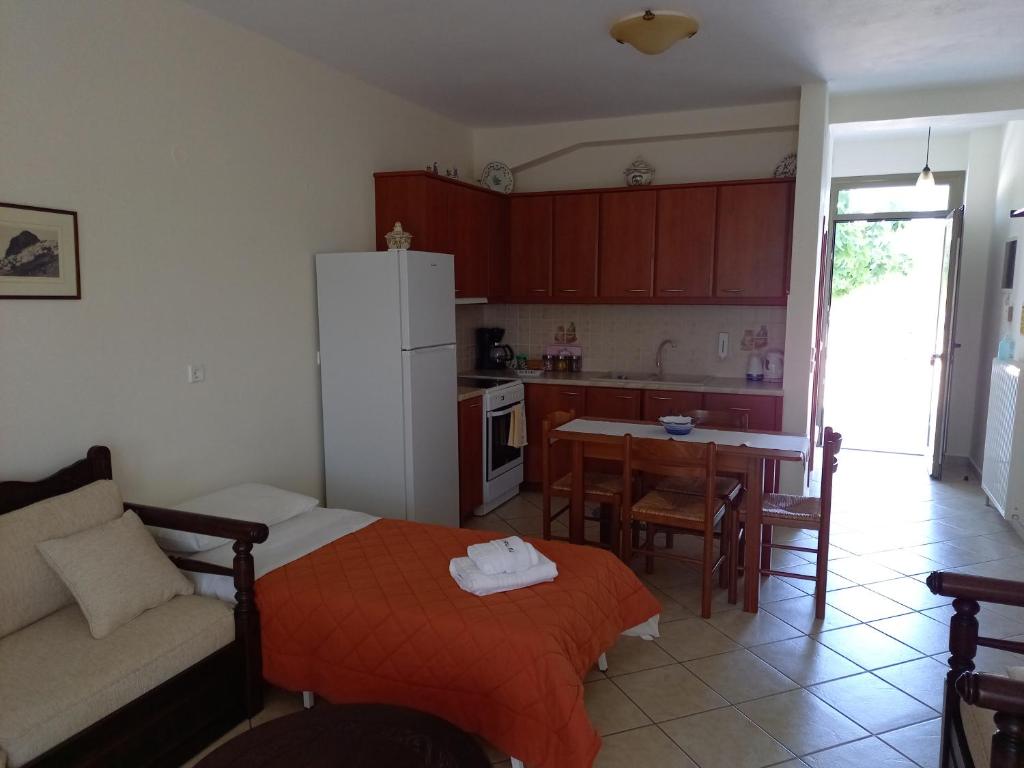 a kitchen and a living room with a couch and a table at To Pithari in Skiros