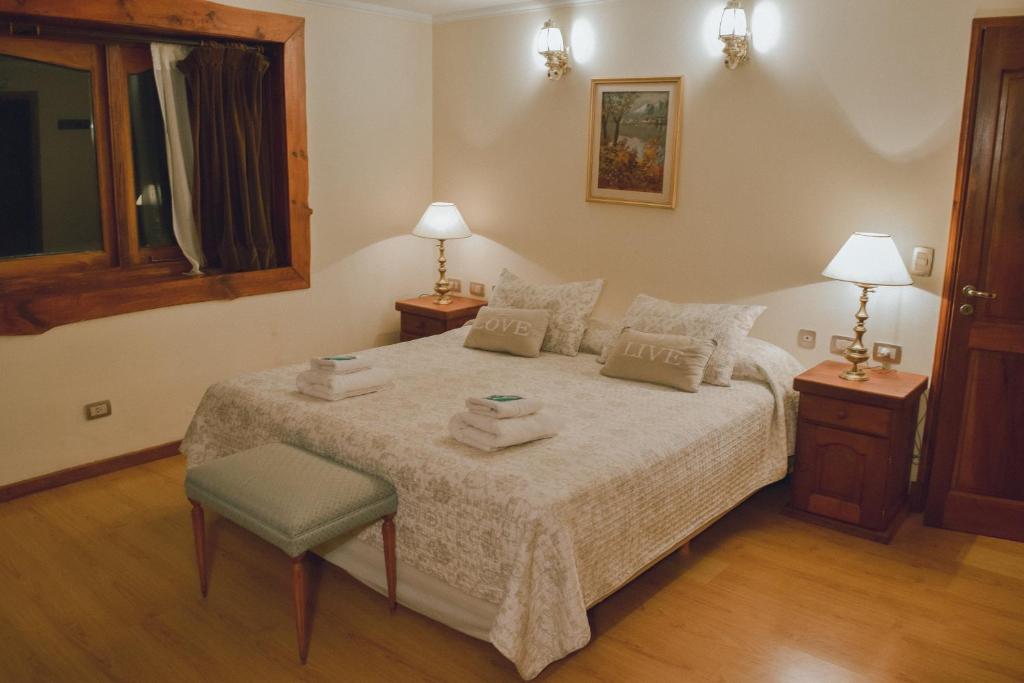 a bedroom with a bed with towels on it at Trawen Hostal Boutique in Caviahue