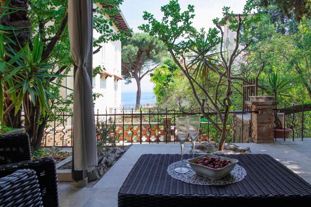 a table with a bowl of fruit and a glass of wine at Apartman Nico, Volosko, PET FRIENDLY in Opatija