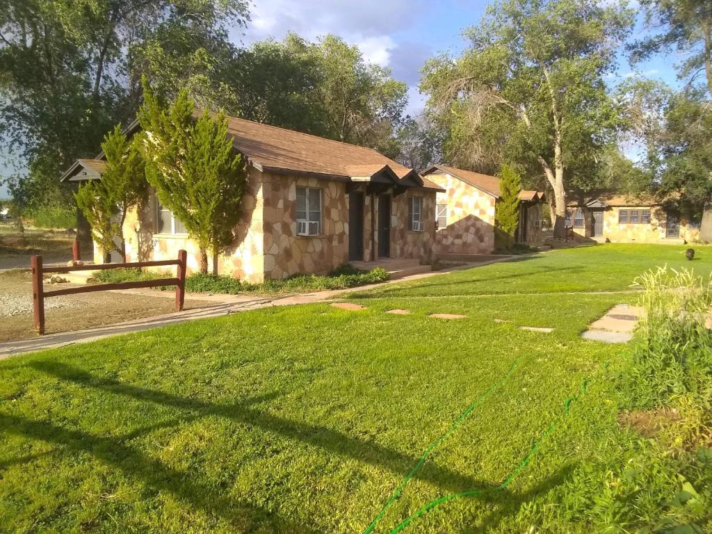 uma casa com um relvado verde em frente em Grand Canyon Cabins em Fredonia