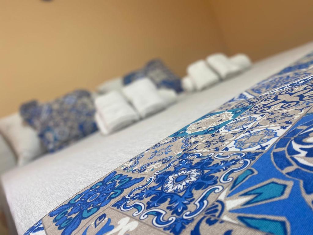 a bed with a blue and white pattern on it at Le Maioliche BLU Sferracavallo in Sferracavallo