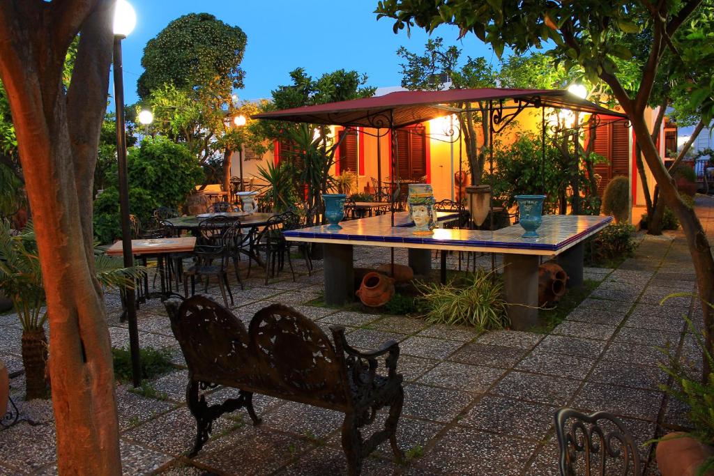 利帕里的住宿－東方酒店，庭院配有桌椅和遮阳伞。