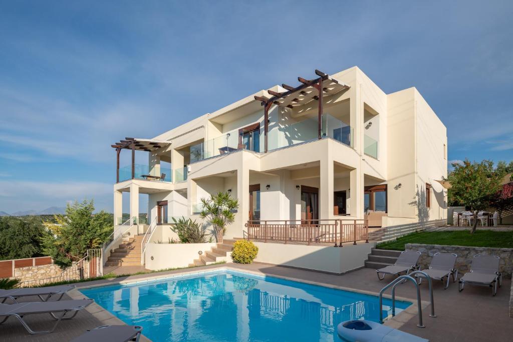 een huis met een zwembad ervoor bij Family Villa Rousa in Rethymno with Pool, BBQ and Kids Area in Loutra
