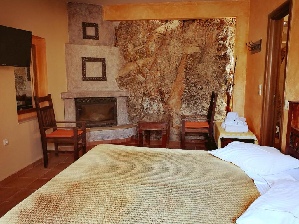 a bedroom with a bed and a fireplace at Flygonion Guesthouse in Kiriákion