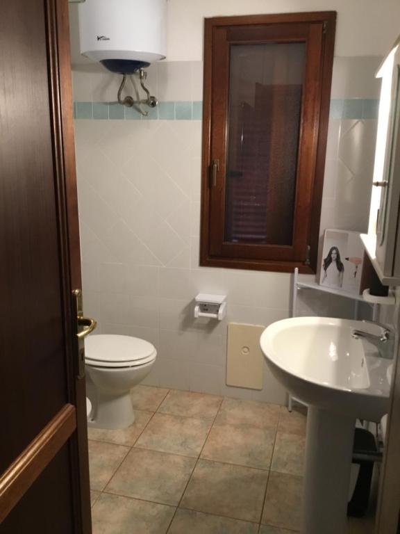 a bathroom with a toilet and a sink at Via Genova 1480 in San Teodoro