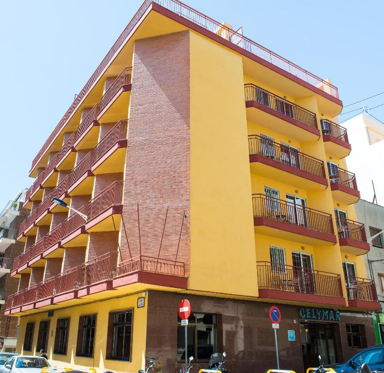 un edificio amarillo con balcones en un lateral en Hotel Celymar, en Benidorm