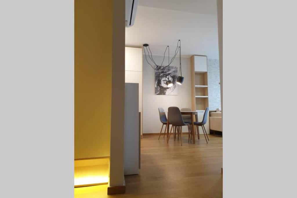 a living room with a table and chairs and a chandelier at Diagonala 2 in Novi Sad