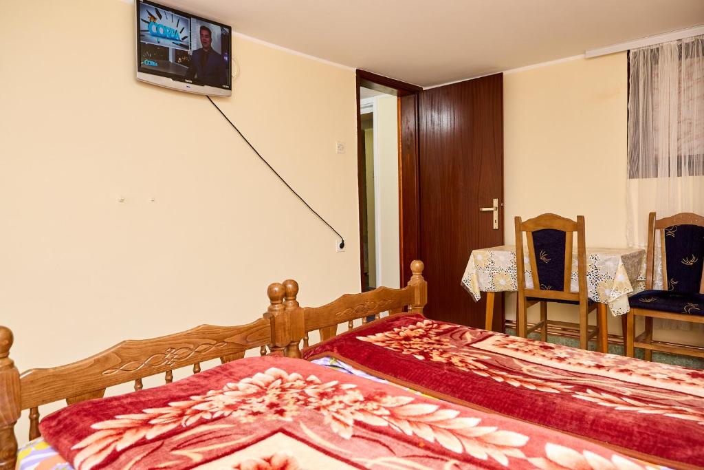 a bedroom with a bed and a tv on the wall at Apartmani Malica in Soko Banja