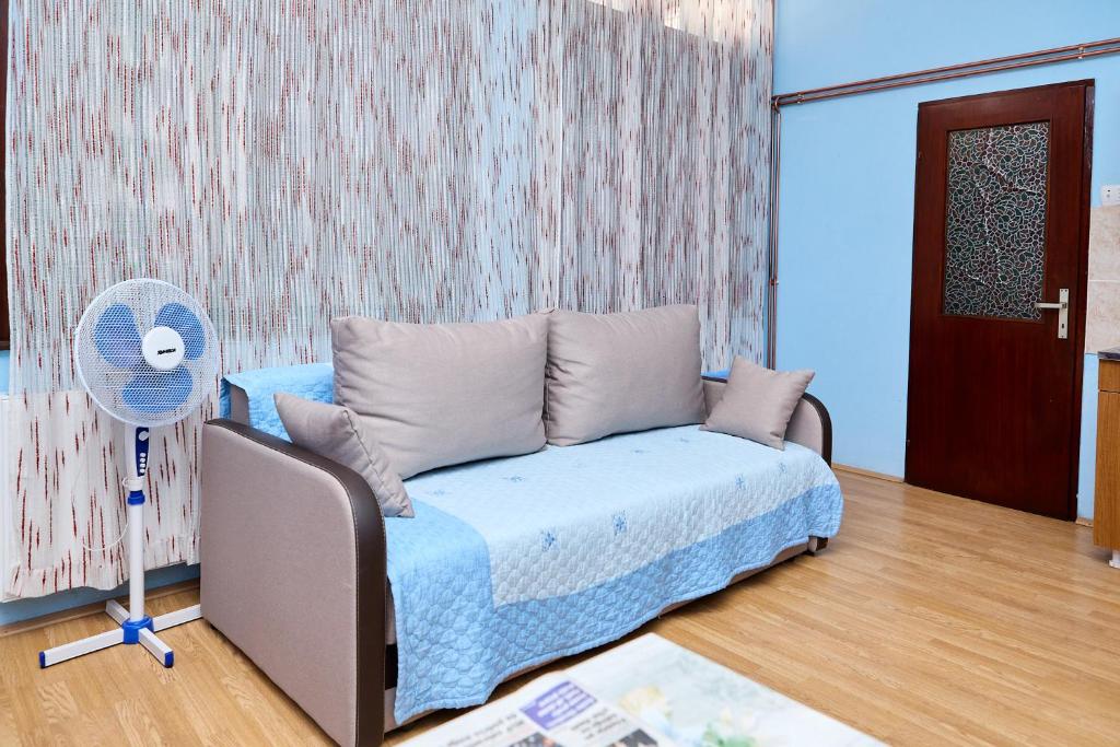 a living room with a couch and a fan at Apartmani Malica in Soko Banja