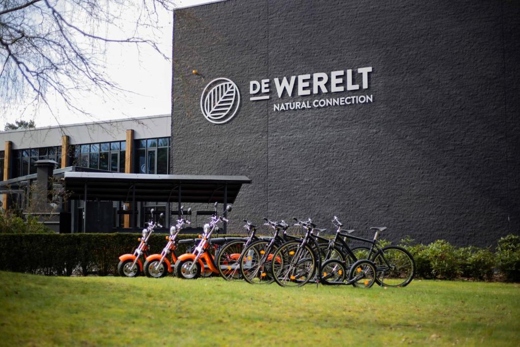 een groep fietsen geparkeerd voor een gebouw bij Hotel de Werelt in Lunteren