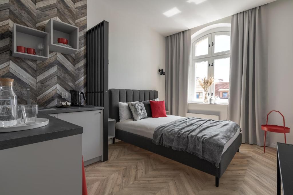 een slaapkamer met een bed en een raam bij HARBOR APARTMENTS - Mariacka in Katowice