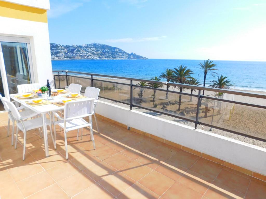 a balcony with a table and chairs and the ocean at GMID IMMO Apartamento Oasis Atico in Roses