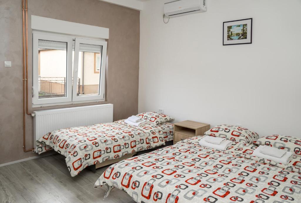 a bedroom with two beds and a window at CITY APARTMENT BB in Bajina Bašta