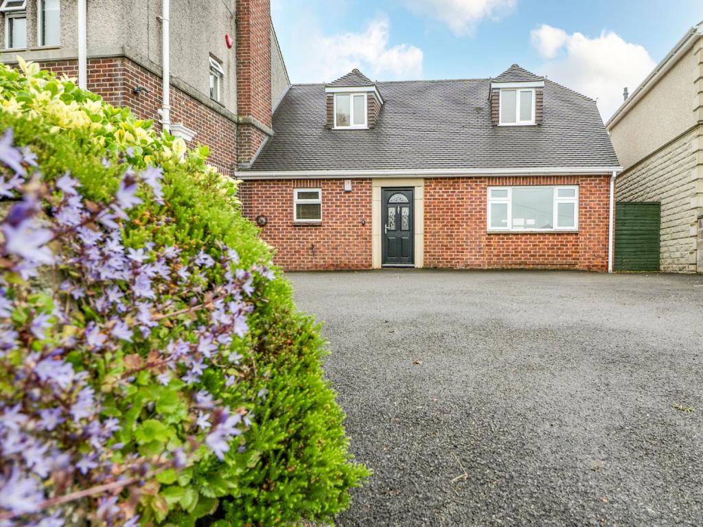 a brick house with a driveway in front of it at Muskoka Lodge in Midsomer Norton