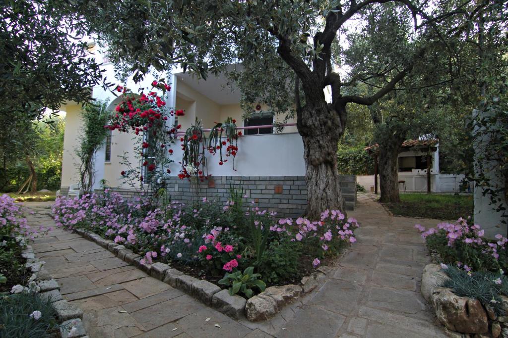 een tuin met bloemen voor een huis bij VILLA RELAX in Skala Kallirakhis