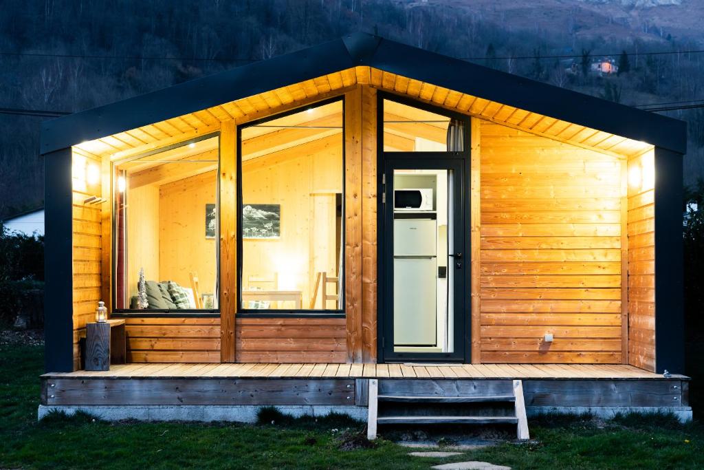 eine Holzhütte mit einer großen Glastür in der Unterkunft Azun Nature in Aucun