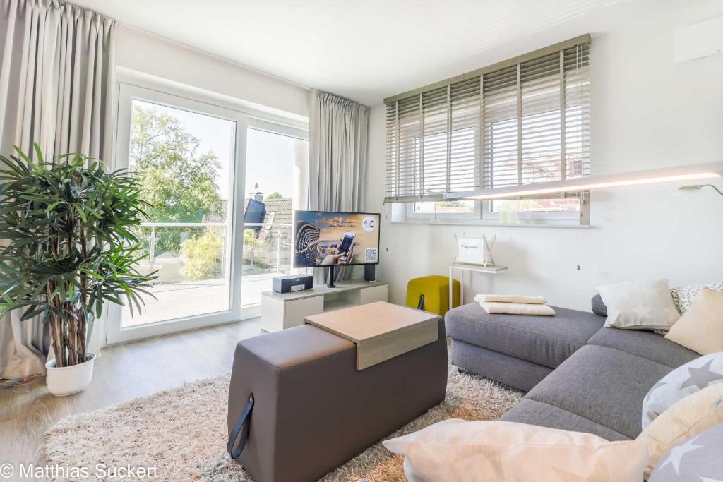 a living room with a couch and a large window at Auszeit am Meer in Hooksiel