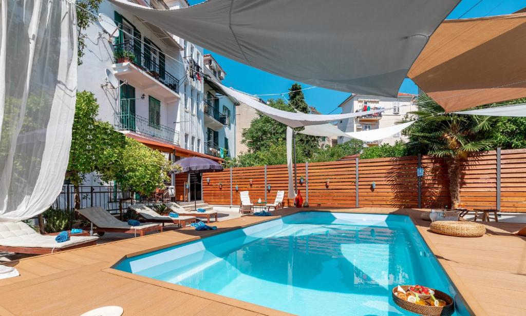a swimming pool on a patio with an umbrella at Evala luxury rooms with pool and garden in Split