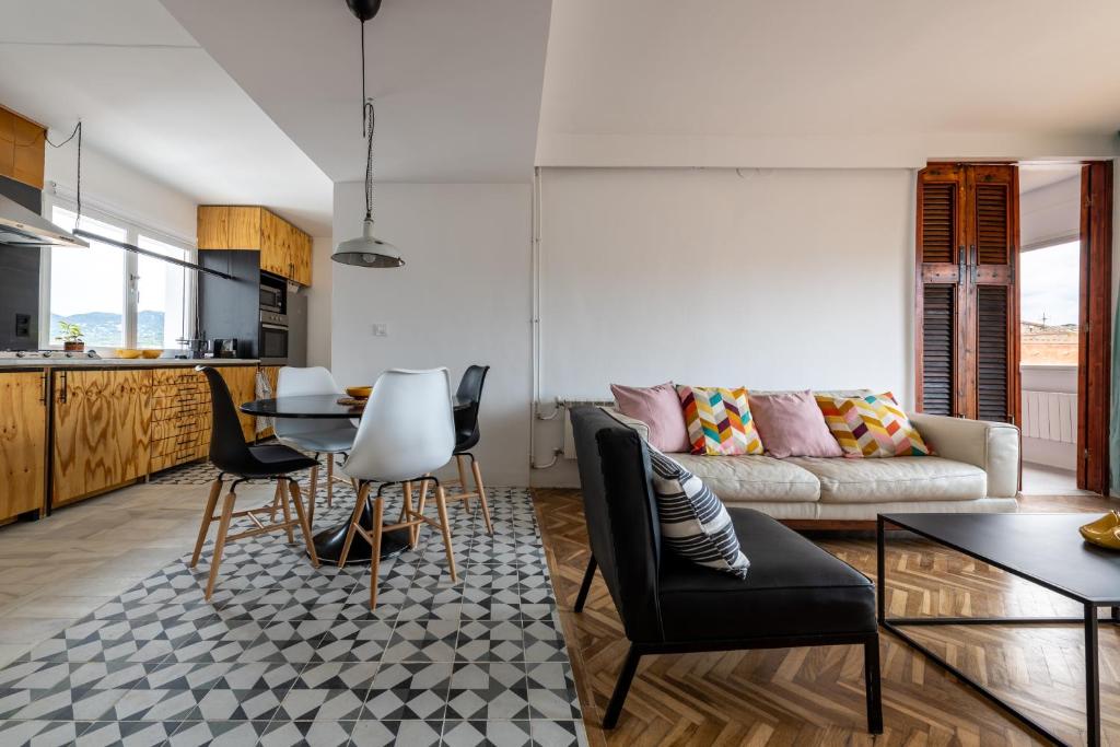 uma sala de estar com um sofá, uma mesa e cadeiras em Casa Creu Mar em Sant Feliu de Guíxols