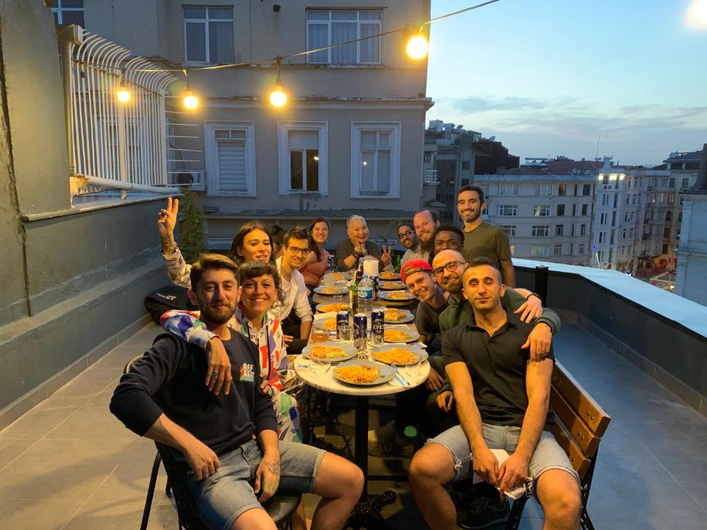 Hostel Le Banc في إسطنبول: مجموعة من الناس يجلسون على طاولة في الشرفة