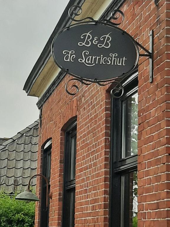 um sinal na lateral de um edifício de tijolos em De Sarrieshut em Houwerzijl