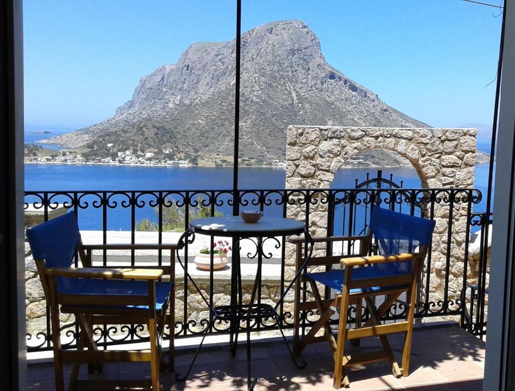 a table and chairs on a balcony with a view of the mountain at Evelinas Apartement in Kalymnos