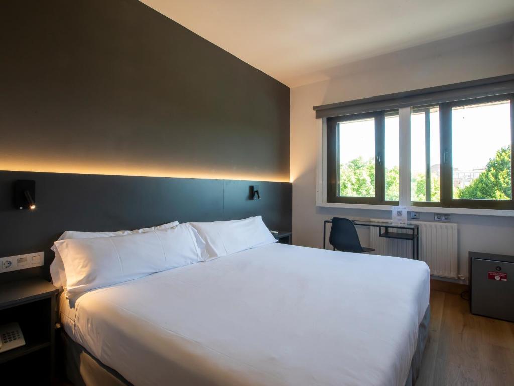 a bedroom with a large white bed and a window at Sancho Ramirez in Pamplona