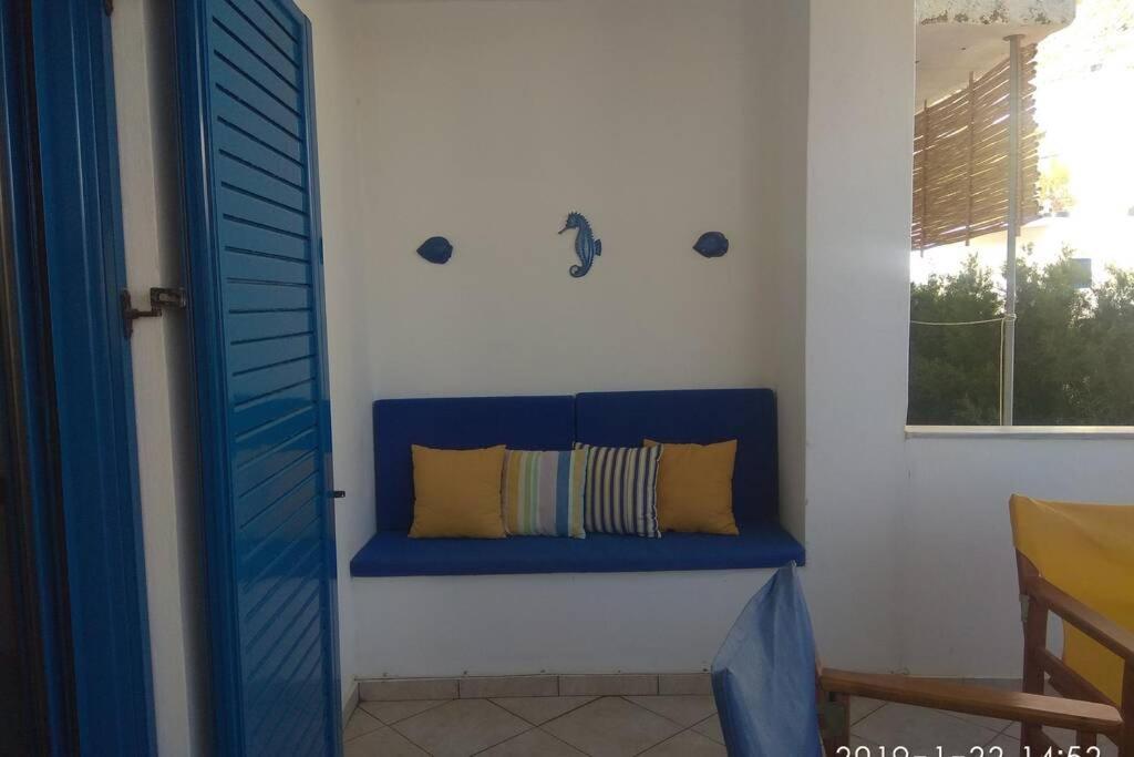 eine blaue Bank in einem Zimmer mit Fenster in der Unterkunft Blue Velvet apartment in Paránimfoi