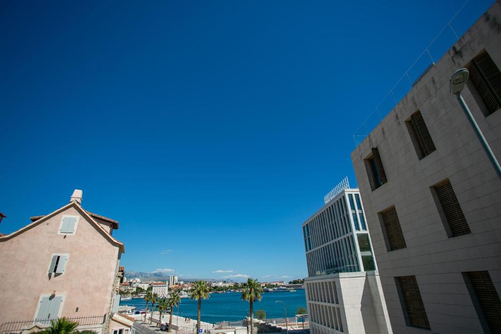 a view of the ocean from between two buildings at Garden Apartment Hotel in Split